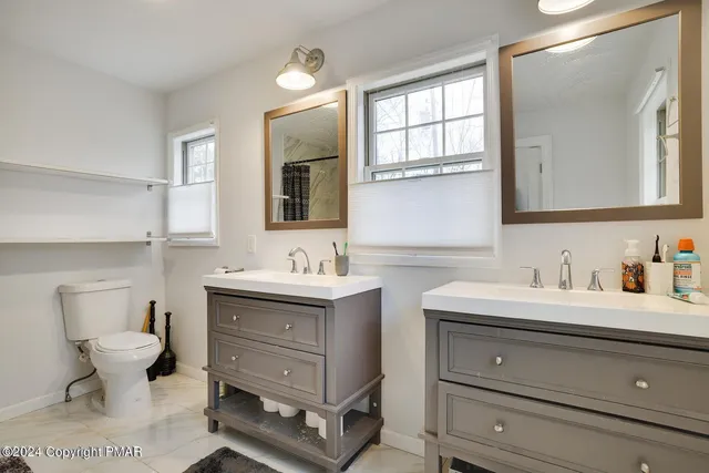 a bathroom with a toilet sink and mirror