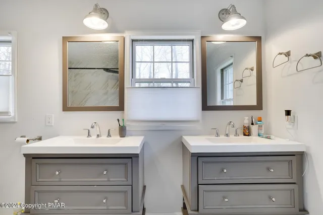 a bathroom with double sink and a mirror
