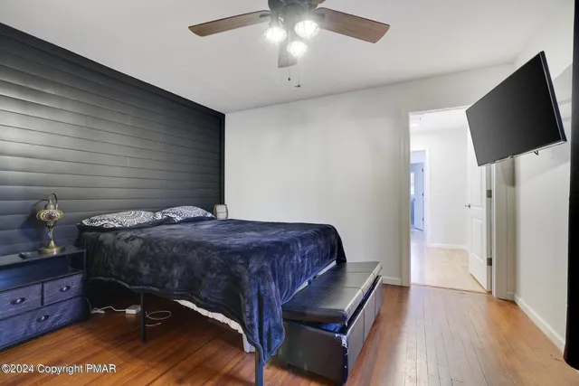 a bedroom with a bed and a flat tv screen on a dresser