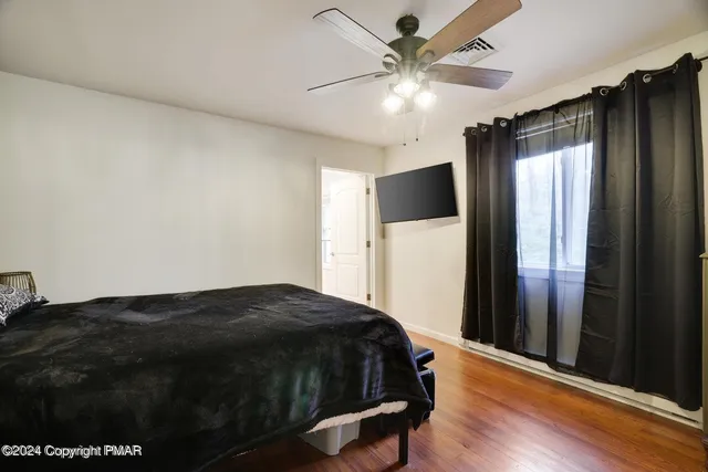 a bedroom with a bed closet and wooden floor