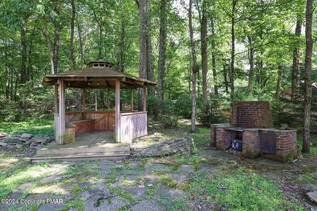 a view of a backyard with table and chairs under an umbrella
