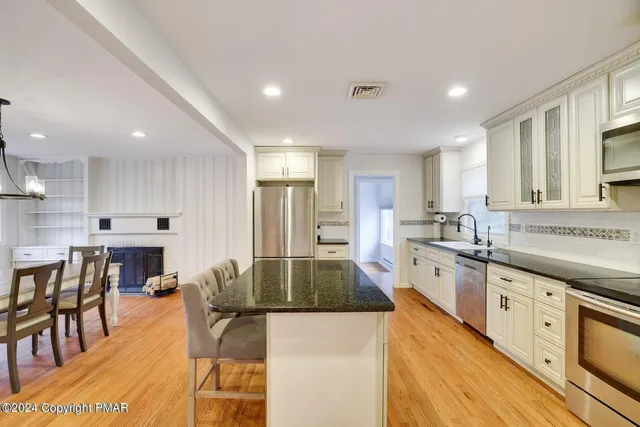 a large kitchen with stainless steel appliances lots of counter space and windows