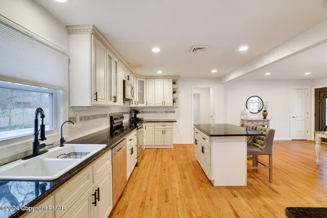 a kitchen with a sink a counter top space a large window and stainless steel appliances