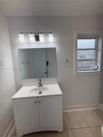 a sink sitting under a bathroom mirror