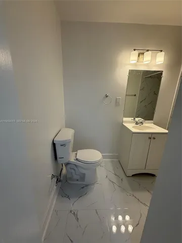 a white toilet sitting next to a bathroom sink