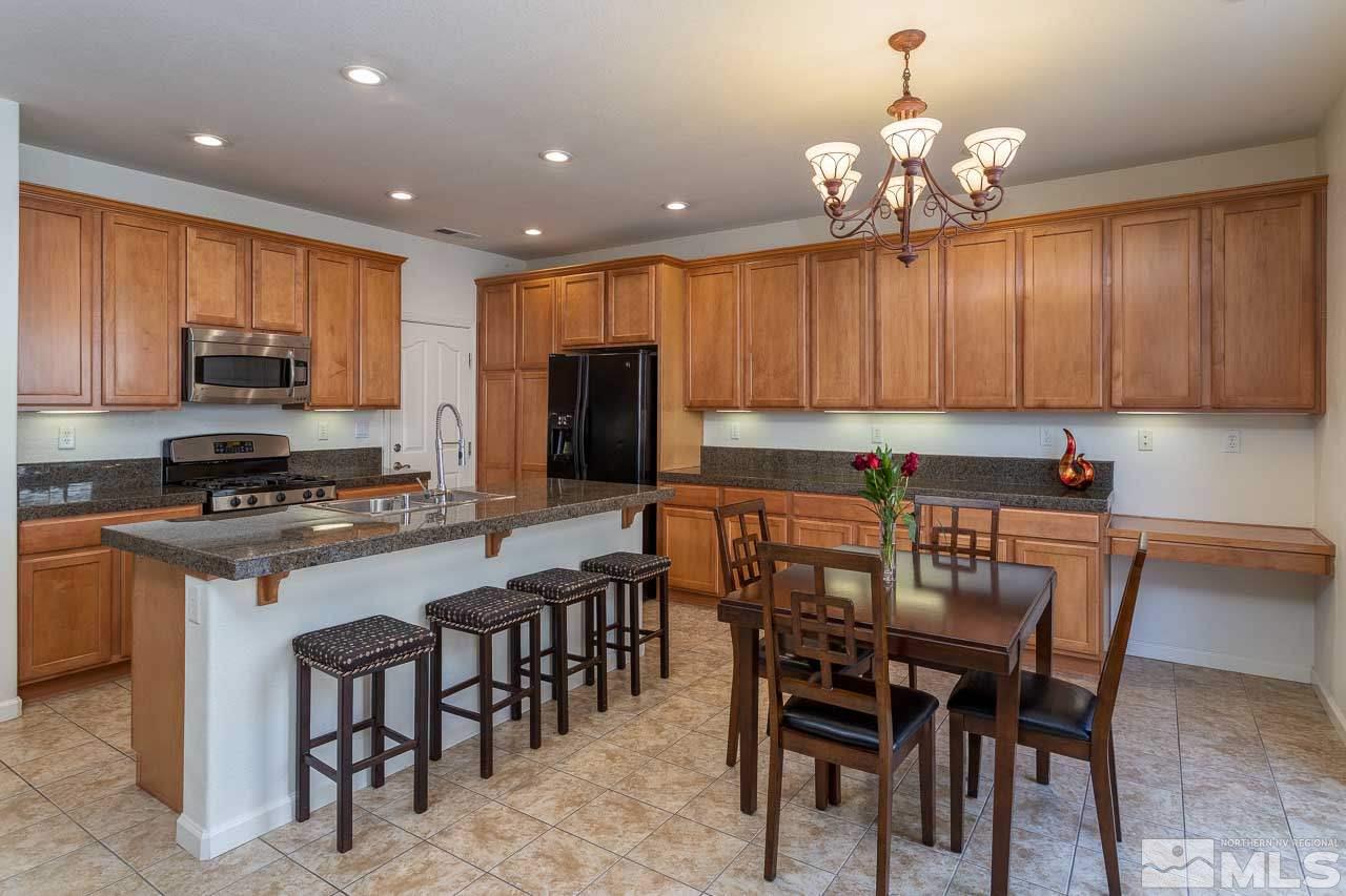 7150 Provence Circle Reno, NV 89523 - Photo 7 of 21 a kitchen with kitchen island granite countertop a sink and a refrigerator