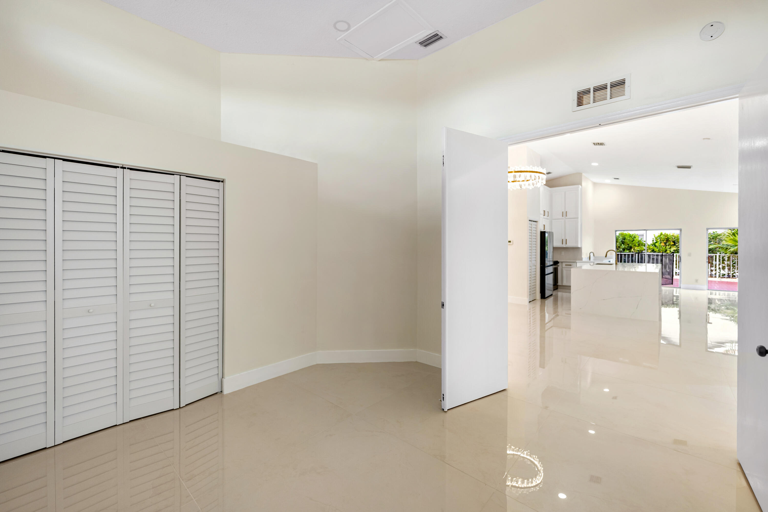17277 Hampton Boulevard Boca Raton, FL 33496 - Photo 21 of 55 en empty room with kitchen natural and wooden floor