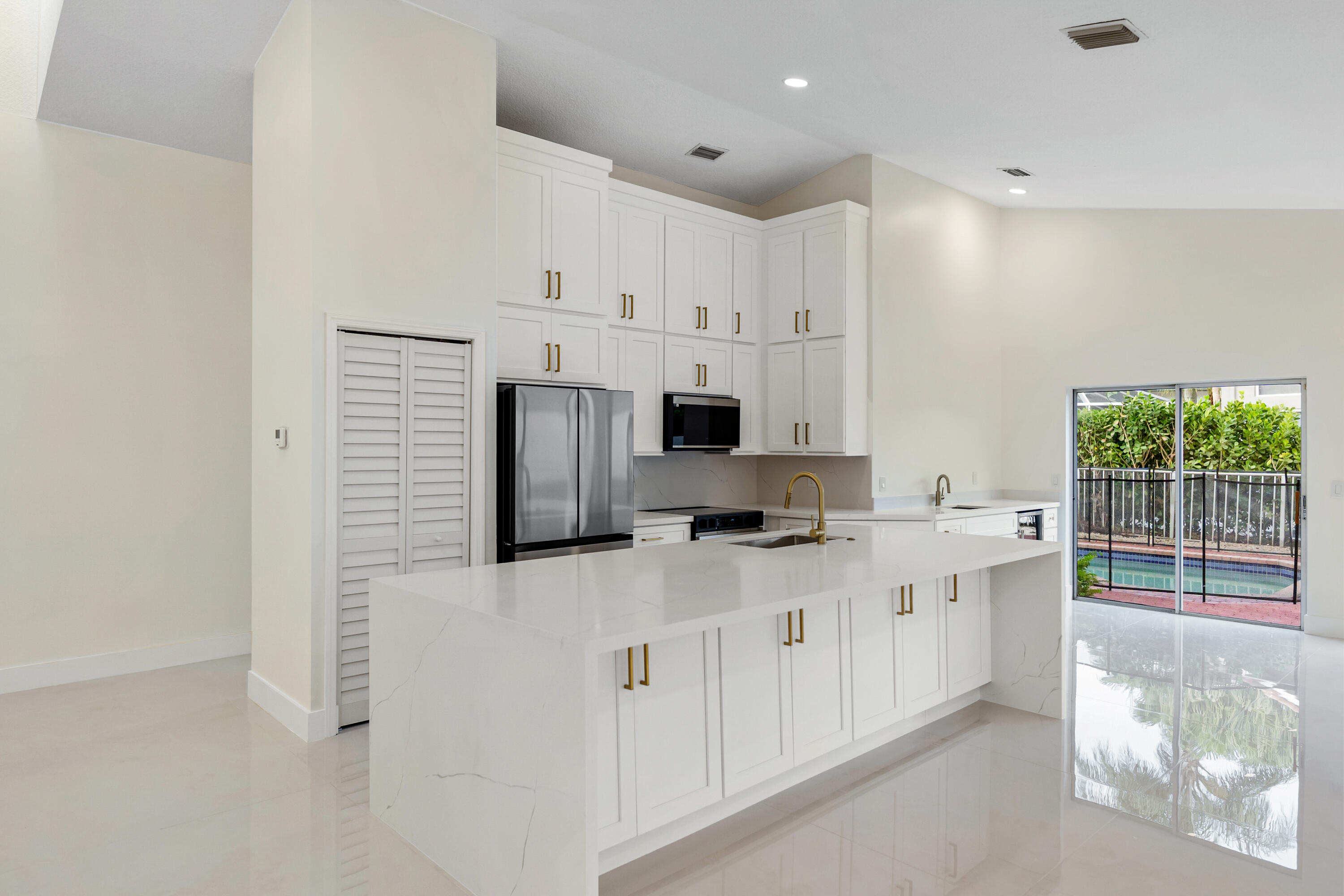 17277 Hampton Boulevard Boca Raton, FL 33496 - Photo 3 of 55 a kitchen with stainless steel appliances a refrigerator sink and cabinets