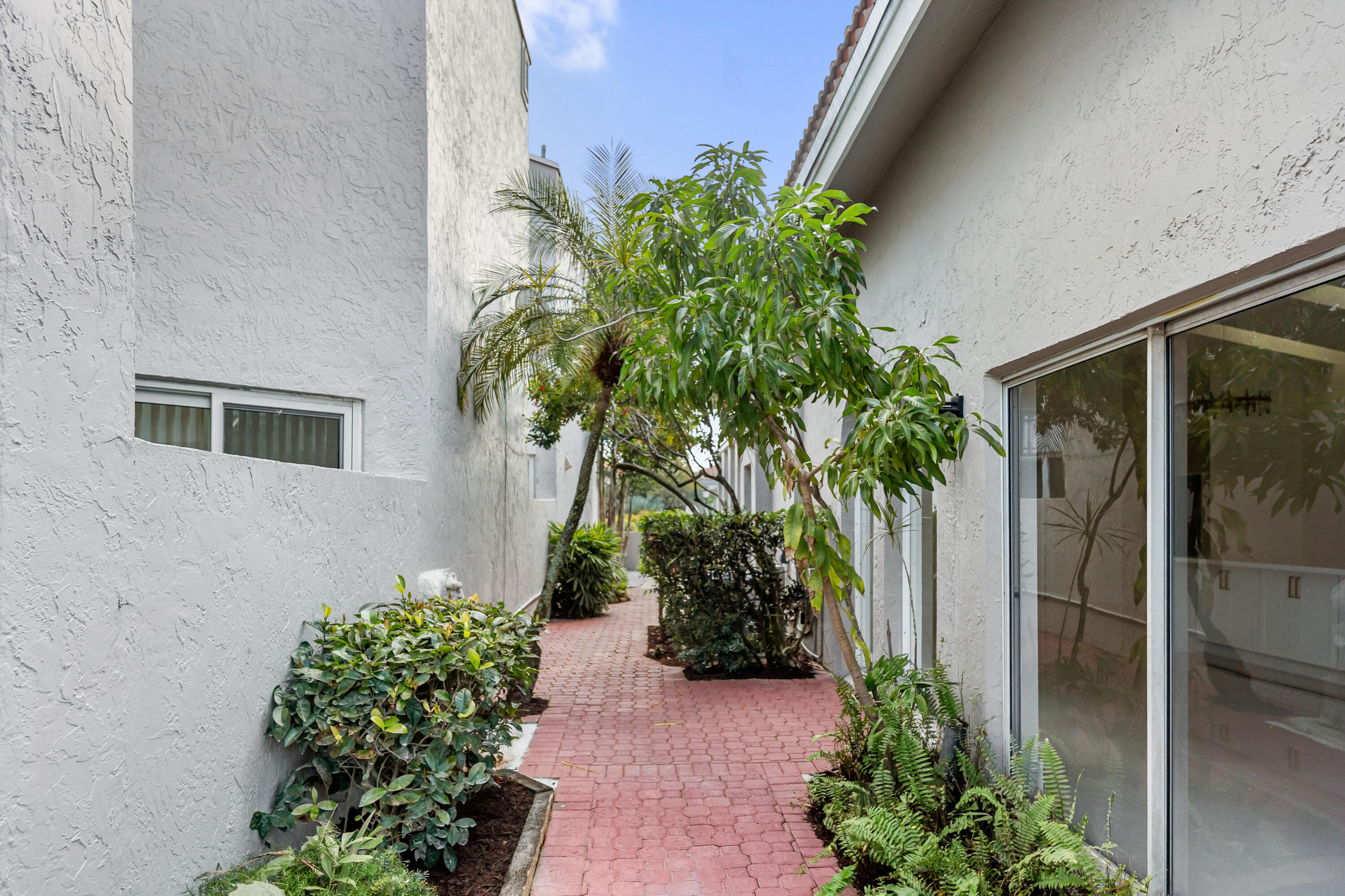 17277 Hampton Boulevard Boca Raton, FL 33496 - Photo 35 of 55 a potted plant sitting in front of a house
