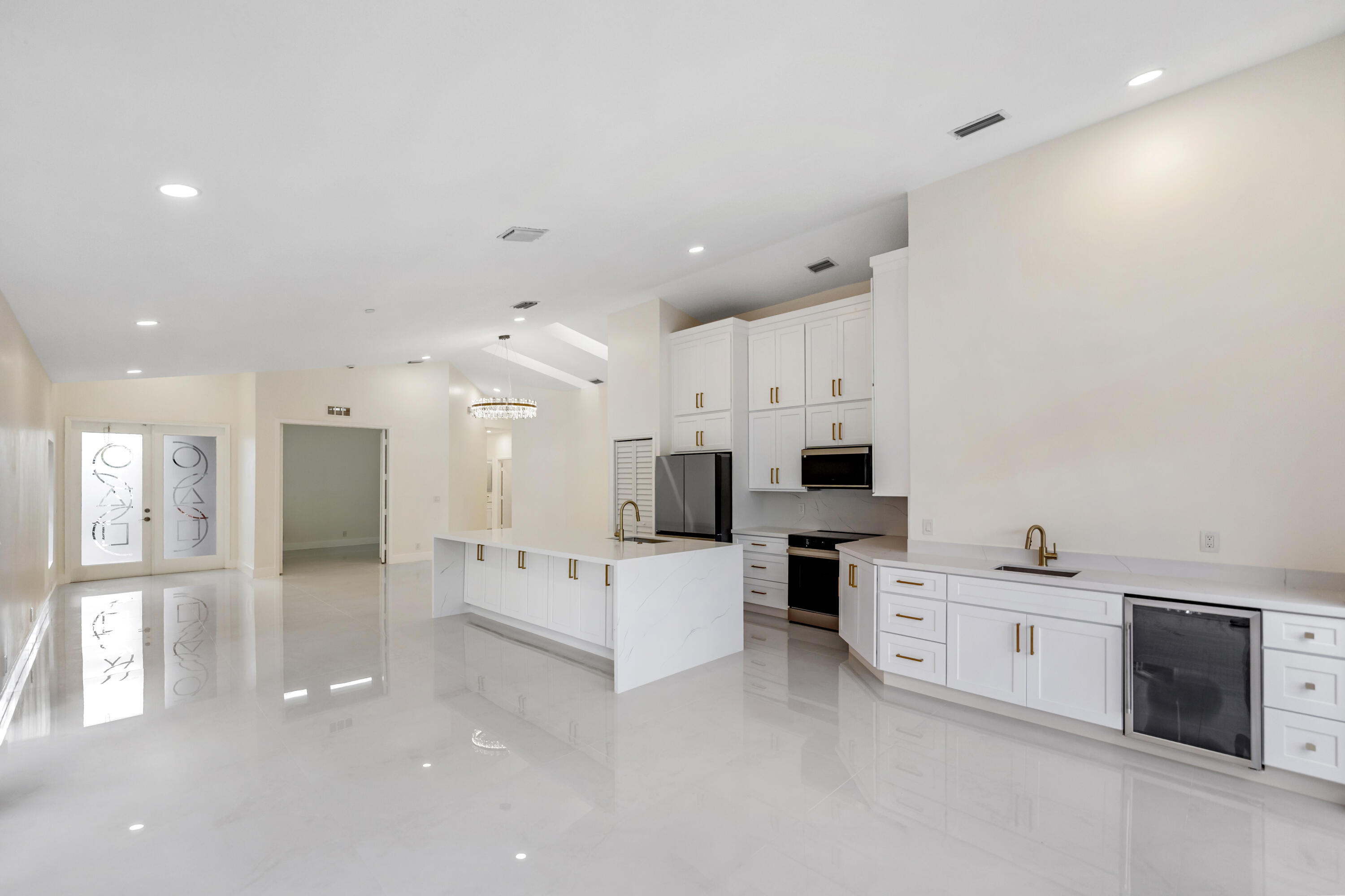 17277 Hampton Boulevard Boca Raton, FL 33496 - Photo 4 of 55 a large white kitchen with stainless steel appliances