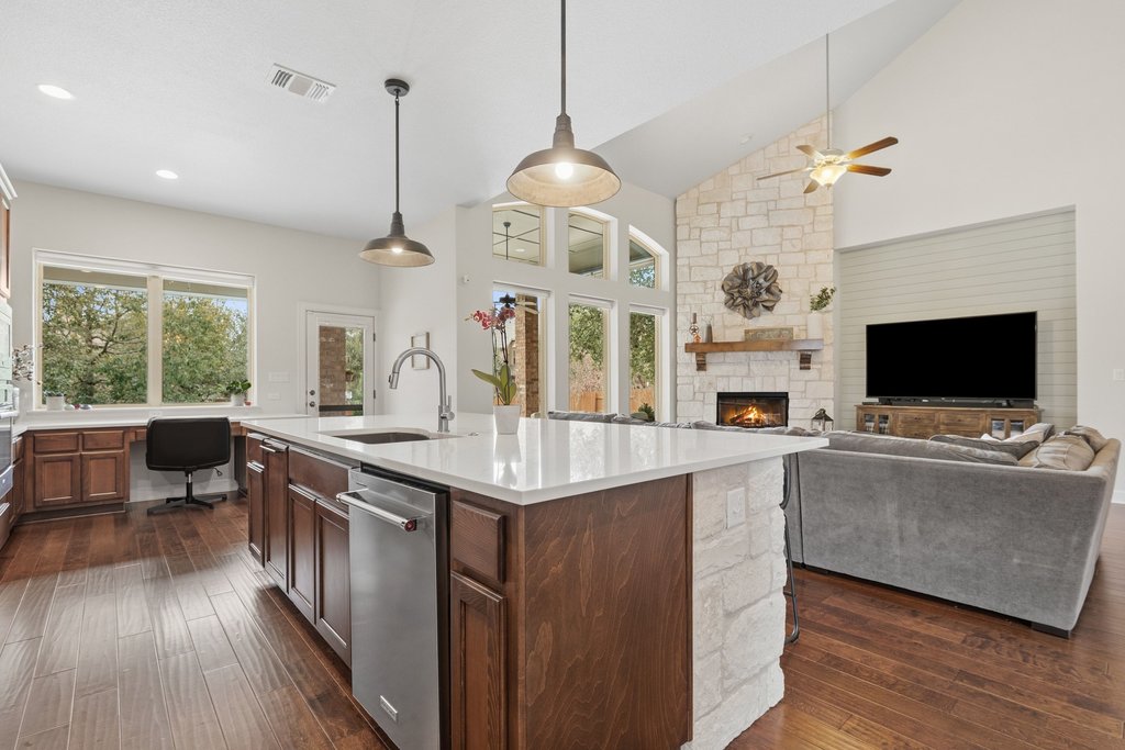 558 Merion Drive Austin, TX 78737 - Photo 11 of 40 a kitchen with stainless steel appliances granite countertop a stove and a wooden floor