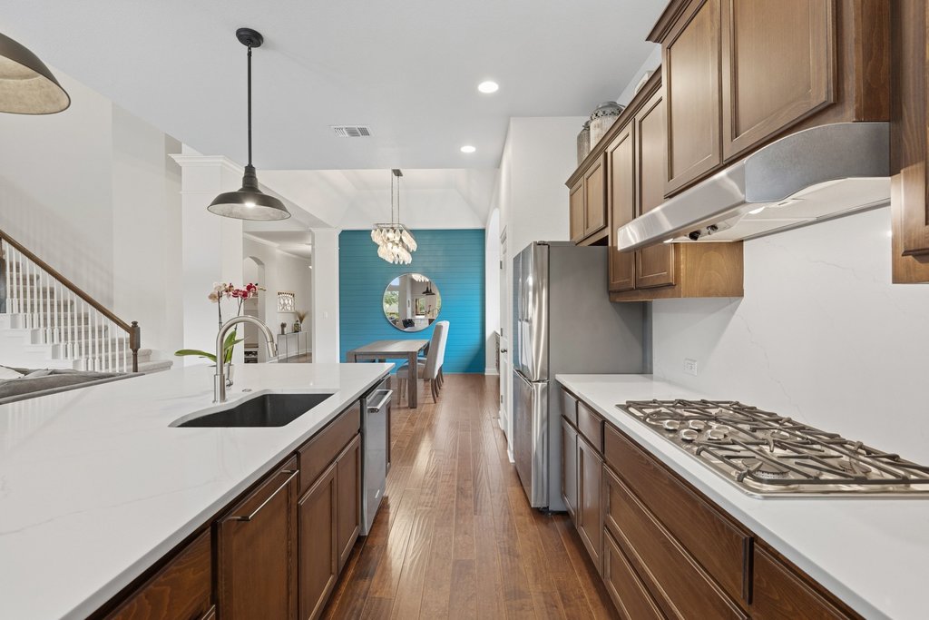 558 Merion Drive Austin, TX 78737 - Photo 13 of 40 a kitchen with stainless steel appliances granite countertop a sink stove and refrigerator