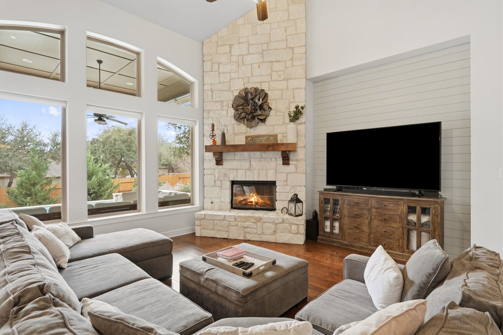 558 Merion Drive Austin, TX 78737 - Photo 16 of 40 a living room with furniture a flat screen tv and a fireplace