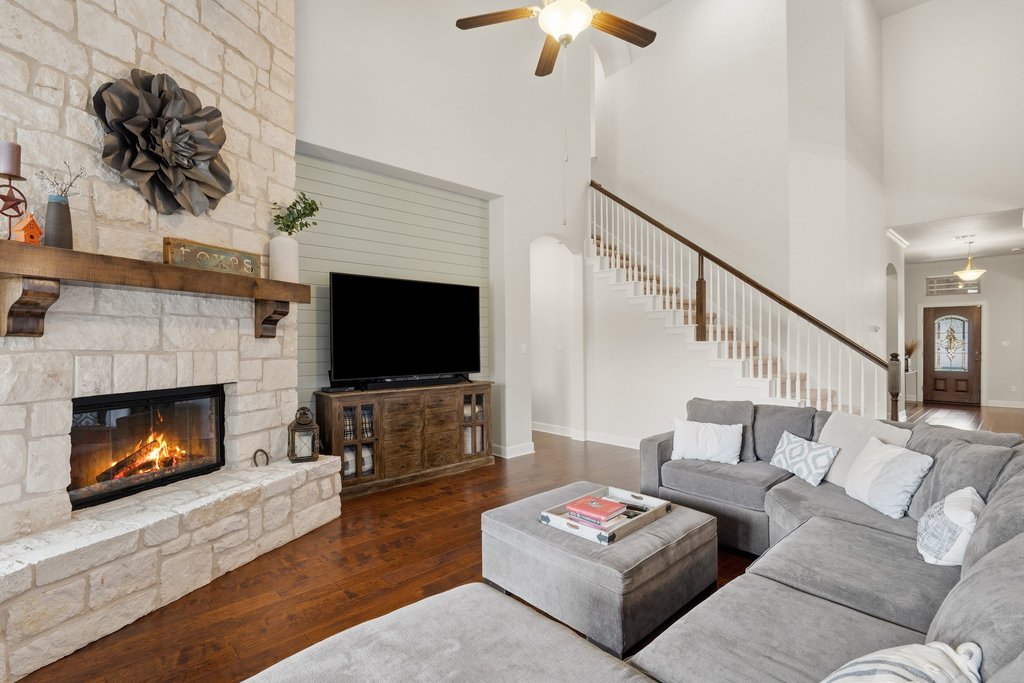 558 Merion Drive Austin, TX 78737 - Photo 19 of 40 a living room with furniture a flat screen tv and a fireplace