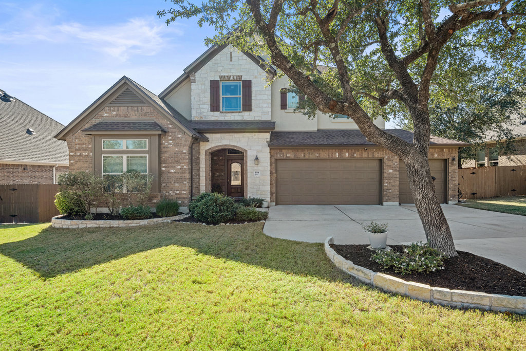 558 Merion Drive Austin, TX 78737 - Photo 2 of 40 a front view of a house with a yard and garage