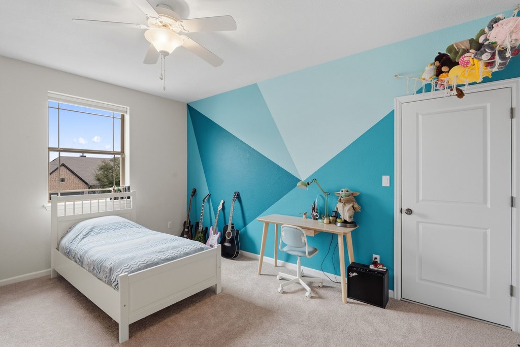 558 Merion Drive Austin, TX 78737 - Photo 28 of 40 a bedroom with a bed and a chandelier