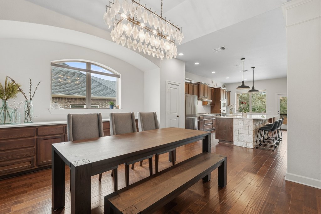 558 Merion Drive Austin, TX 78737 - Photo 7 of 40 a dining room with furniture a chandelier and wooden floor