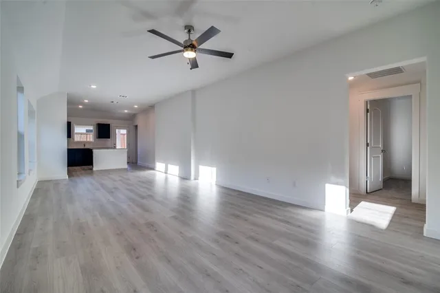a view of a livingroom with wooden floor and a ceiling fan