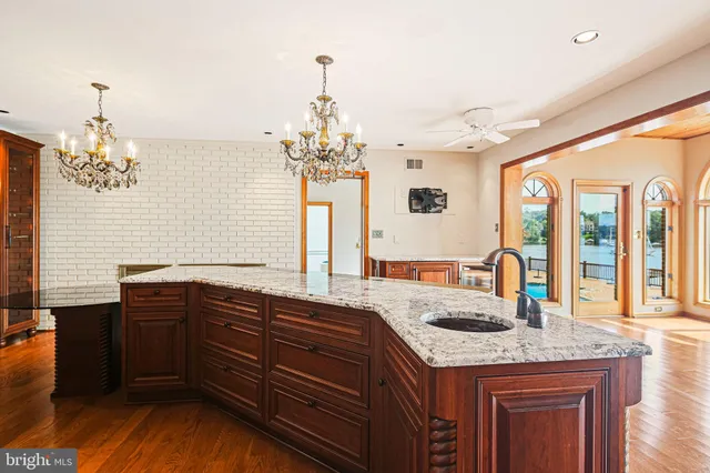 a dining room with furniture a chandelier and wooden floor