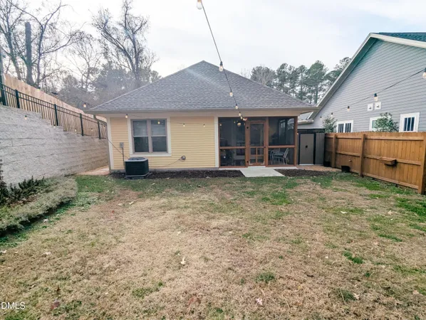 a view of a house with a yard and wooden fence