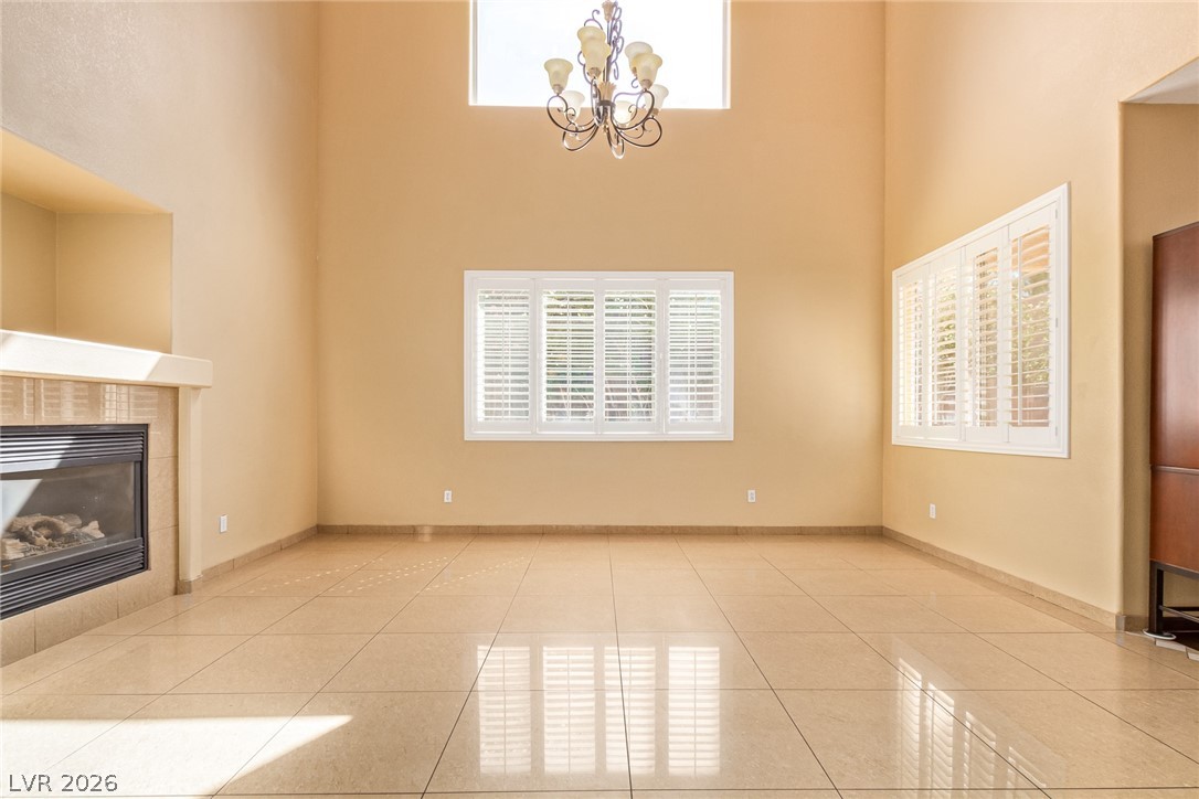 1477 Rancho Ridge Drive Henderson, NV 89012 - Photo 9 of 46 A spacious living area with soaring ceilings and a cozy fireplace, perfect for gatherings.