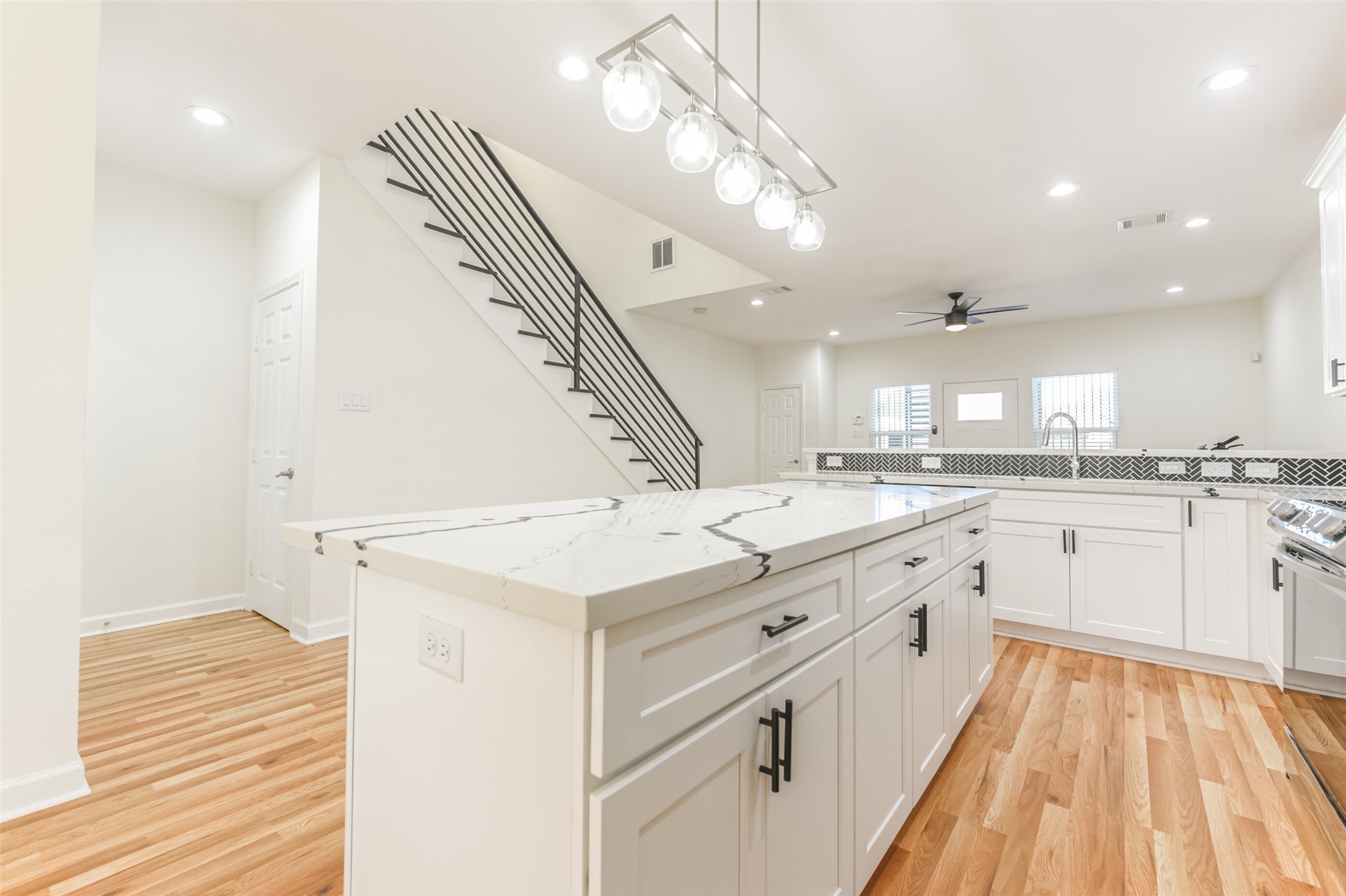 4830 Burma Road, Unit A B Houston, TX 77033 - Photo 11 of 34 a large white kitchen with a large window a sink and cabinets
