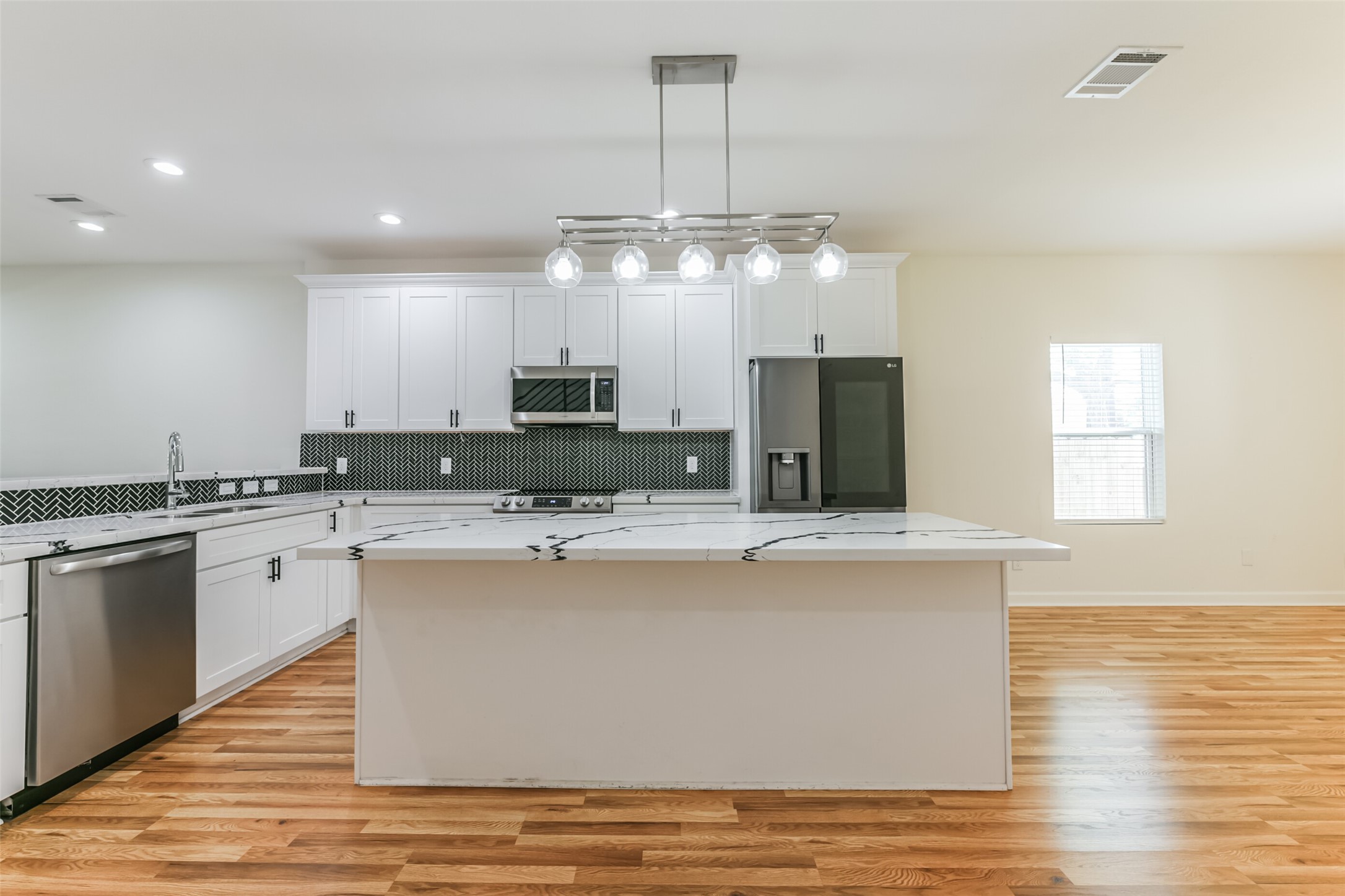 4830 Burma Road, Unit A B Houston, TX 77033 - Photo 14 of 34 a kitchen with kitchen island granite countertop a sink cabinets and wooden floor