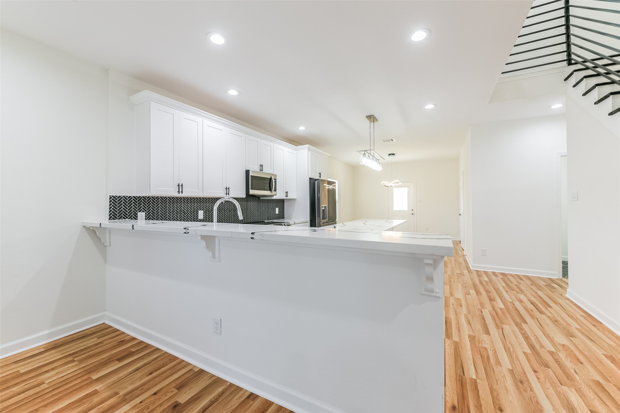 4830 Burma Road, Unit A B Houston, TX 77033 - Photo 8 of 34 a view of a kitchen with kitchen island a sink wooden floor and a refrigerator