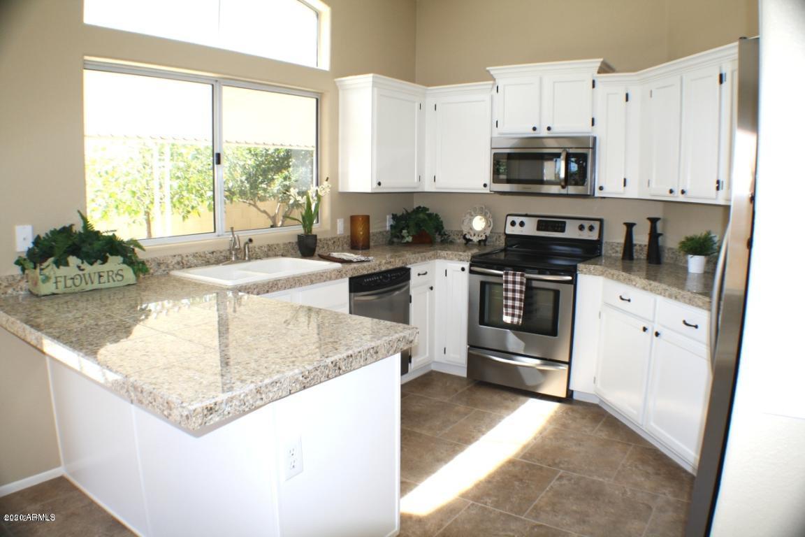 4745 East St John Road Phoenix, AZ 85032 - Photo 13 of 20 a kitchen with stainless steel appliances granite countertop a sink stove and refrigerator