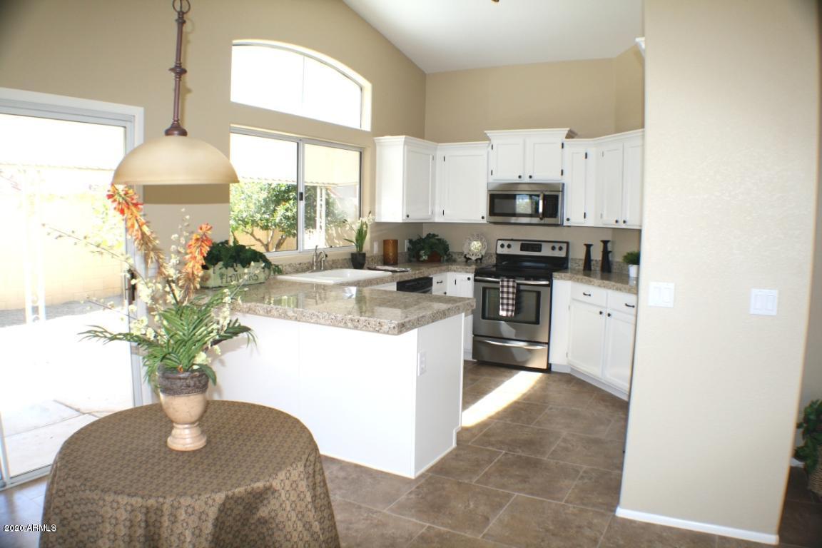 4745 East St John Road Phoenix, AZ 85032 - Photo 14 of 20 a kitchen with stainless steel appliances granite countertop a stove a sink a microwave and a window