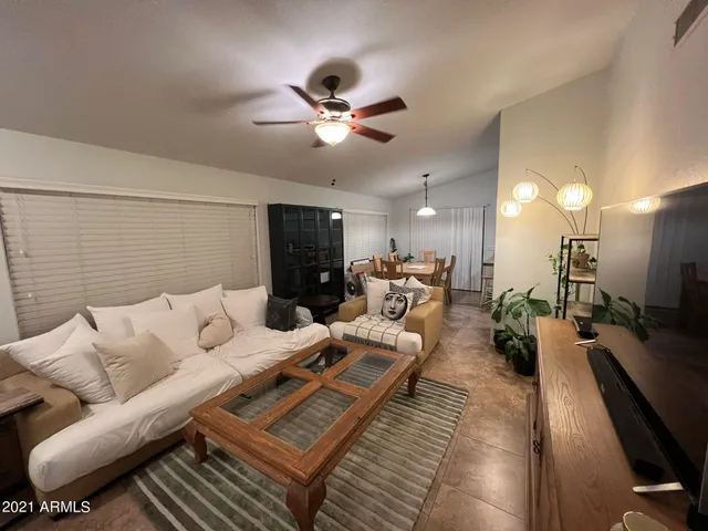 a living room with furniture kitchen view and a chandelier
