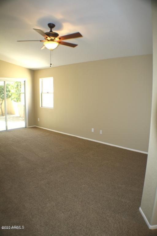 4745 East St John Road Phoenix, AZ 85032 - Photo 6 of 20 an empty room with a chandelier fan and windows