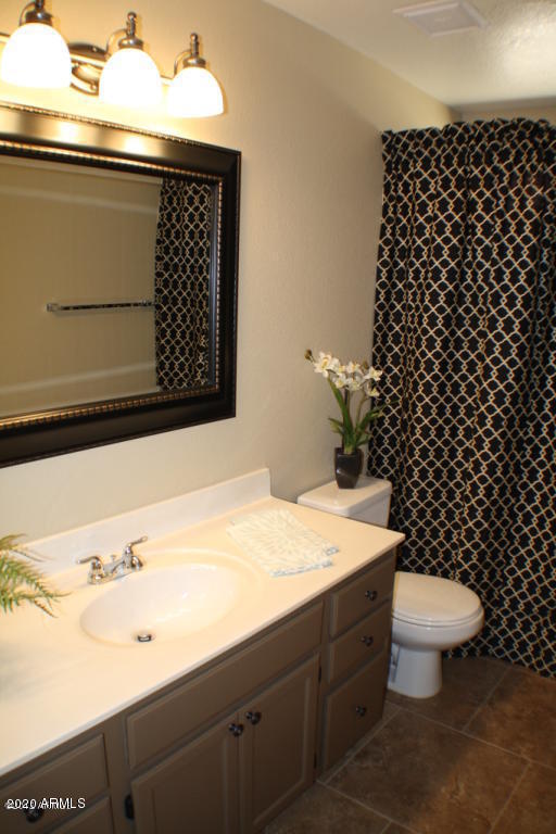 4745 East St John Road Phoenix, AZ 85032 - Photo 7 of 20 a bathroom with a sink a toilet and a mirror