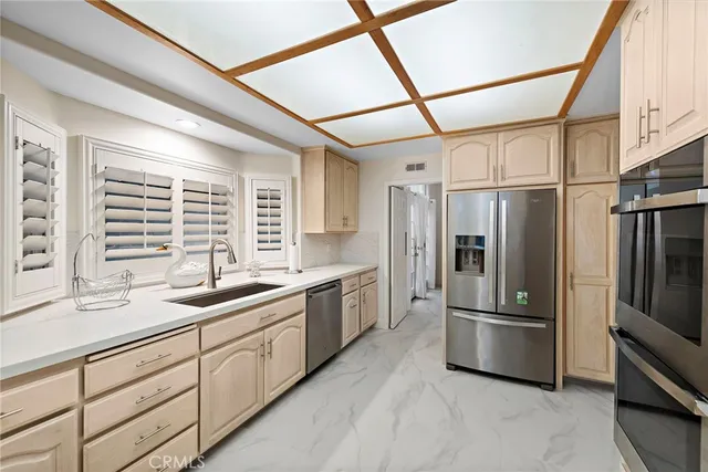 a kitchen with stainless steel appliances a refrigerator sink and cabinets