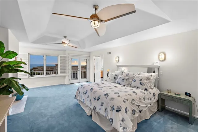 a bedroom with a large bed and a chandelier