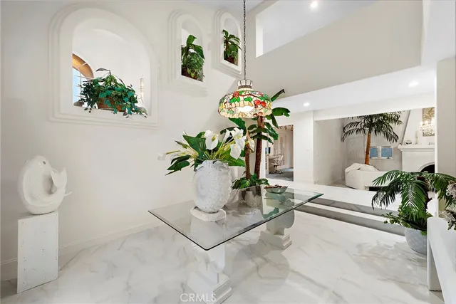 a white vase with white and yellow flowers