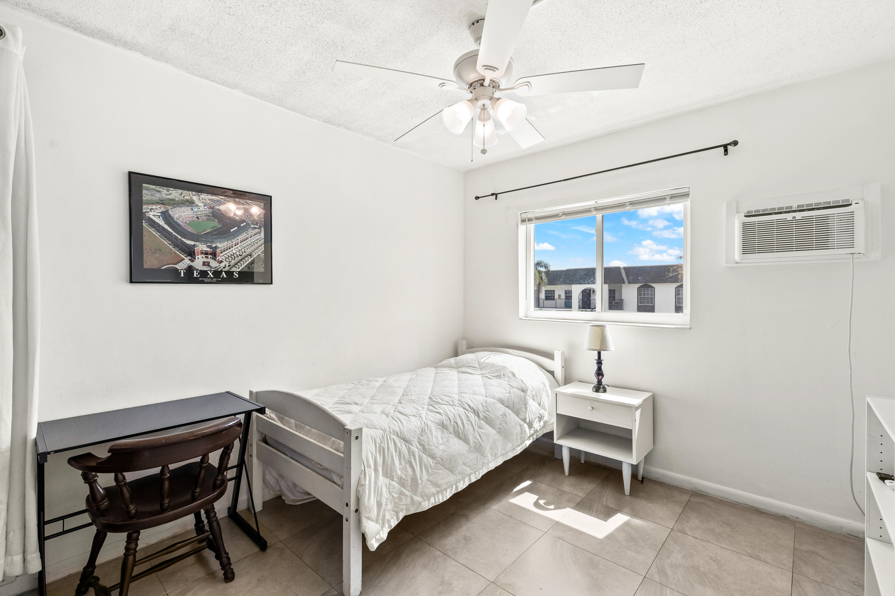 1021 Northeast 24th Avenue, Unit 12 Pompano Beach, FL 33062 - Photo 22 of 33 a bedroom with a bed and a chandelier