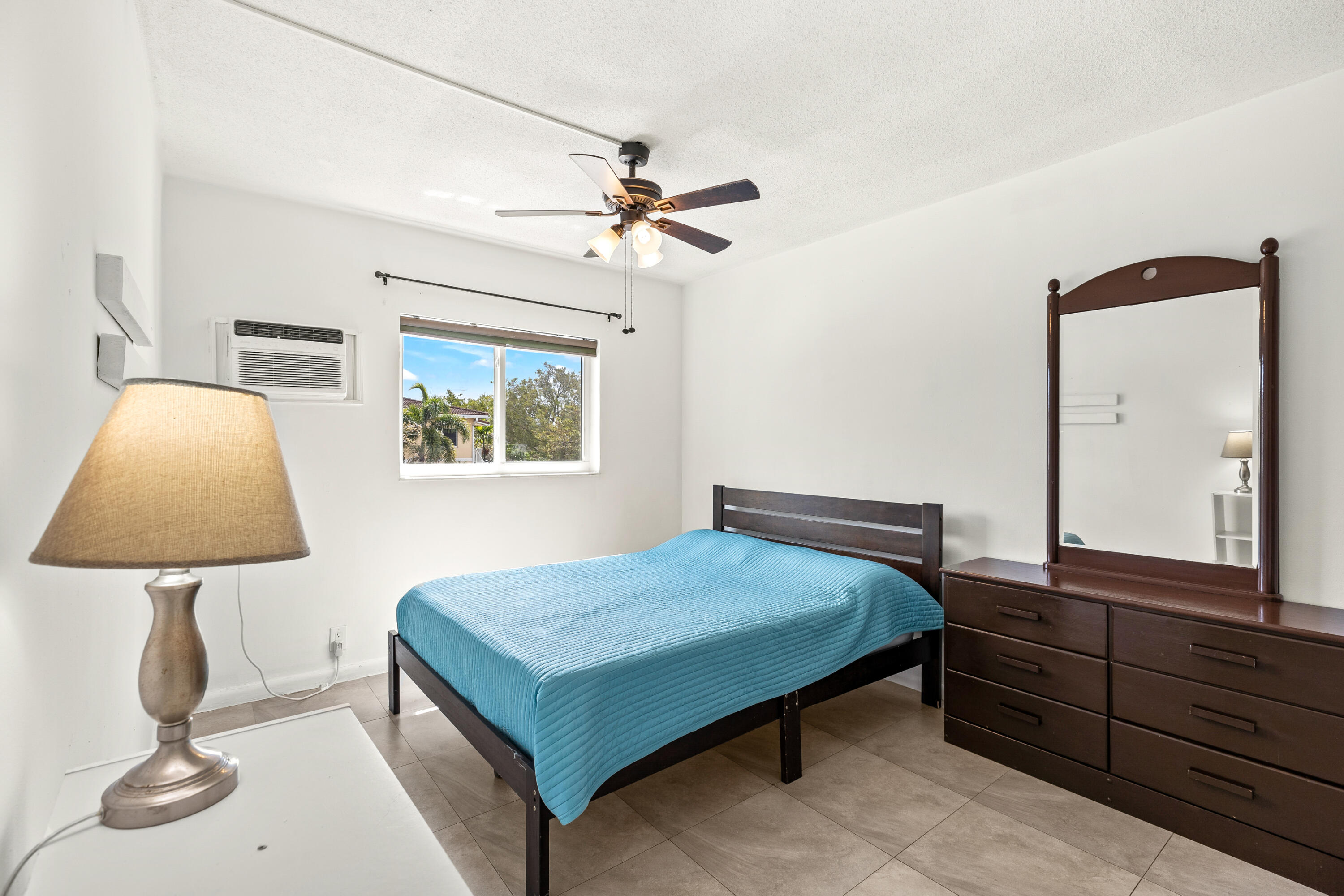 1021 Northeast 24th Avenue, Unit 12 Pompano Beach, FL 33062 - Photo 23 of 33 a bedroom with a bed and a lamp on table