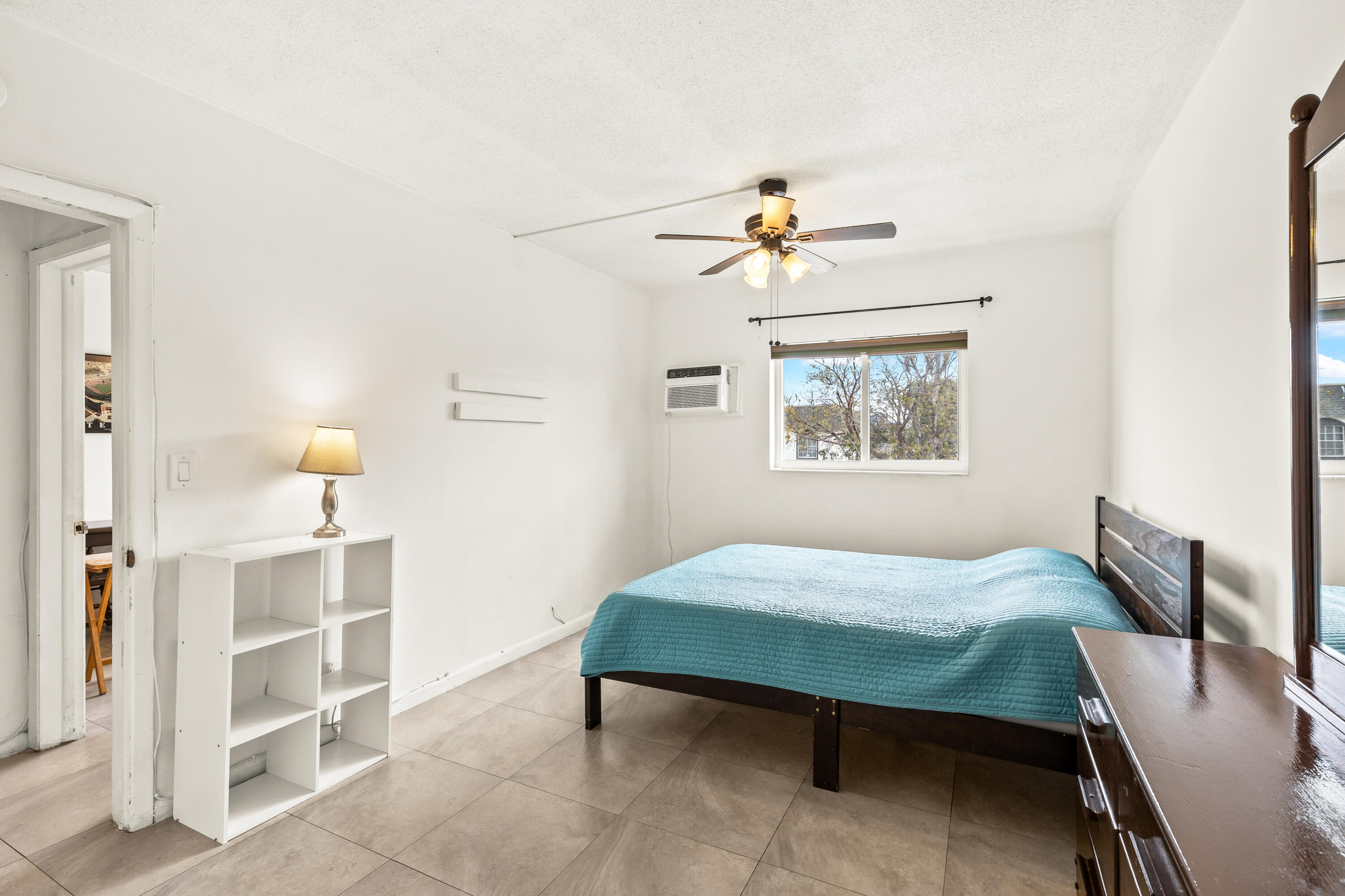 1021 Northeast 24th Avenue, Unit 12 Pompano Beach, FL 33062 - Photo 26 of 33 a bedroom with a bed and a chandelier