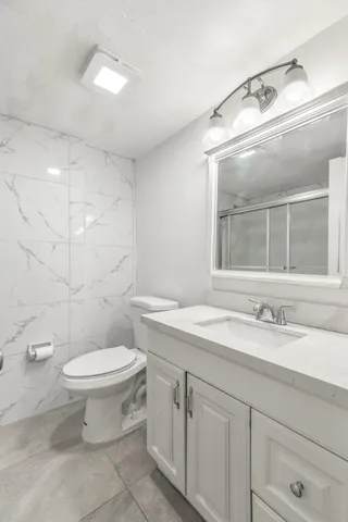 a bathroom with a sink a toilet and shower