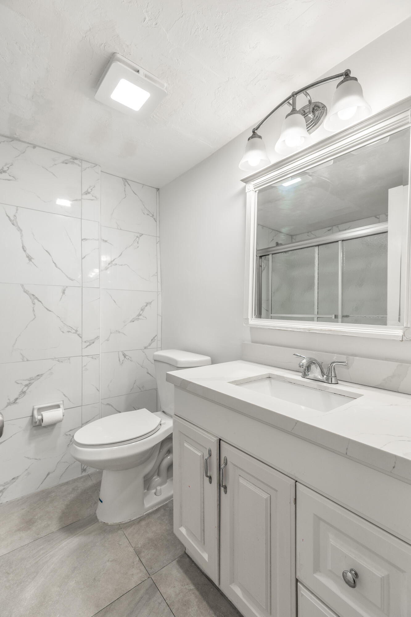 1021 Northeast 24th Avenue, Unit 12 Pompano Beach, FL 33062 - Photo 27 of 33 a bathroom with a granite countertop toilet a sink and a mirror