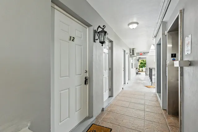 a view of a hallway with a dining area and a glass door