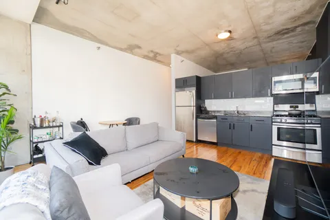 a living room with stainless steel appliances kitchen island granite countertop furniture and a kitchen view