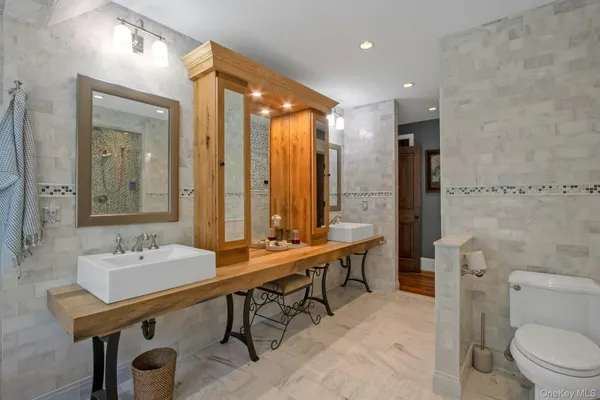 a bathroom with a sink a toilet a mirror and shower