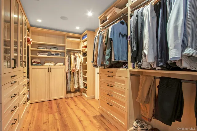 a view of walk in closet with clothes and shoes