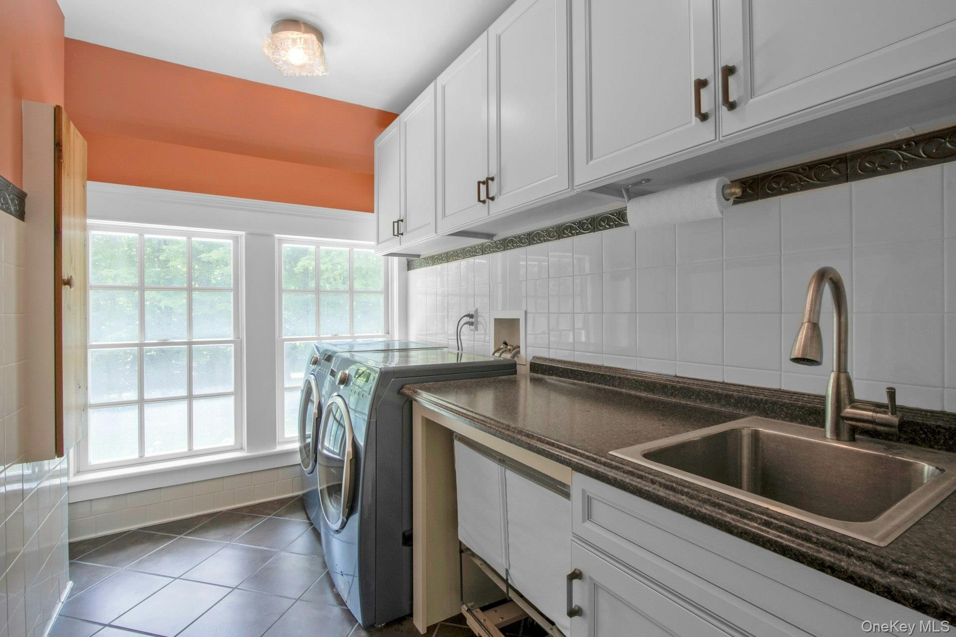 314 Haverstraw Road Suffern, NY 10901 - Photo 27 of 44 Washroom with washer and dryer, healthy amount of natural light, tile patterned flooring, and cabinet space