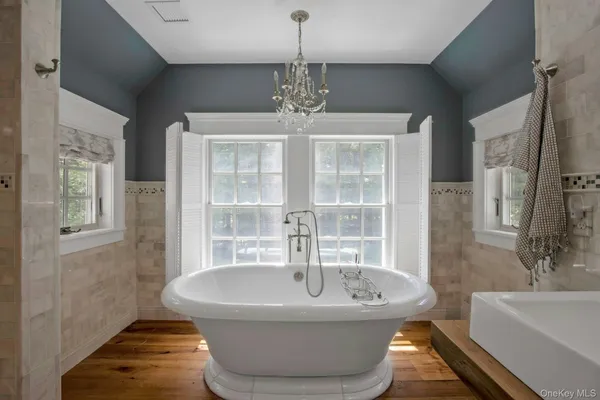 a spacious bathroom with a bathtub and chandelier