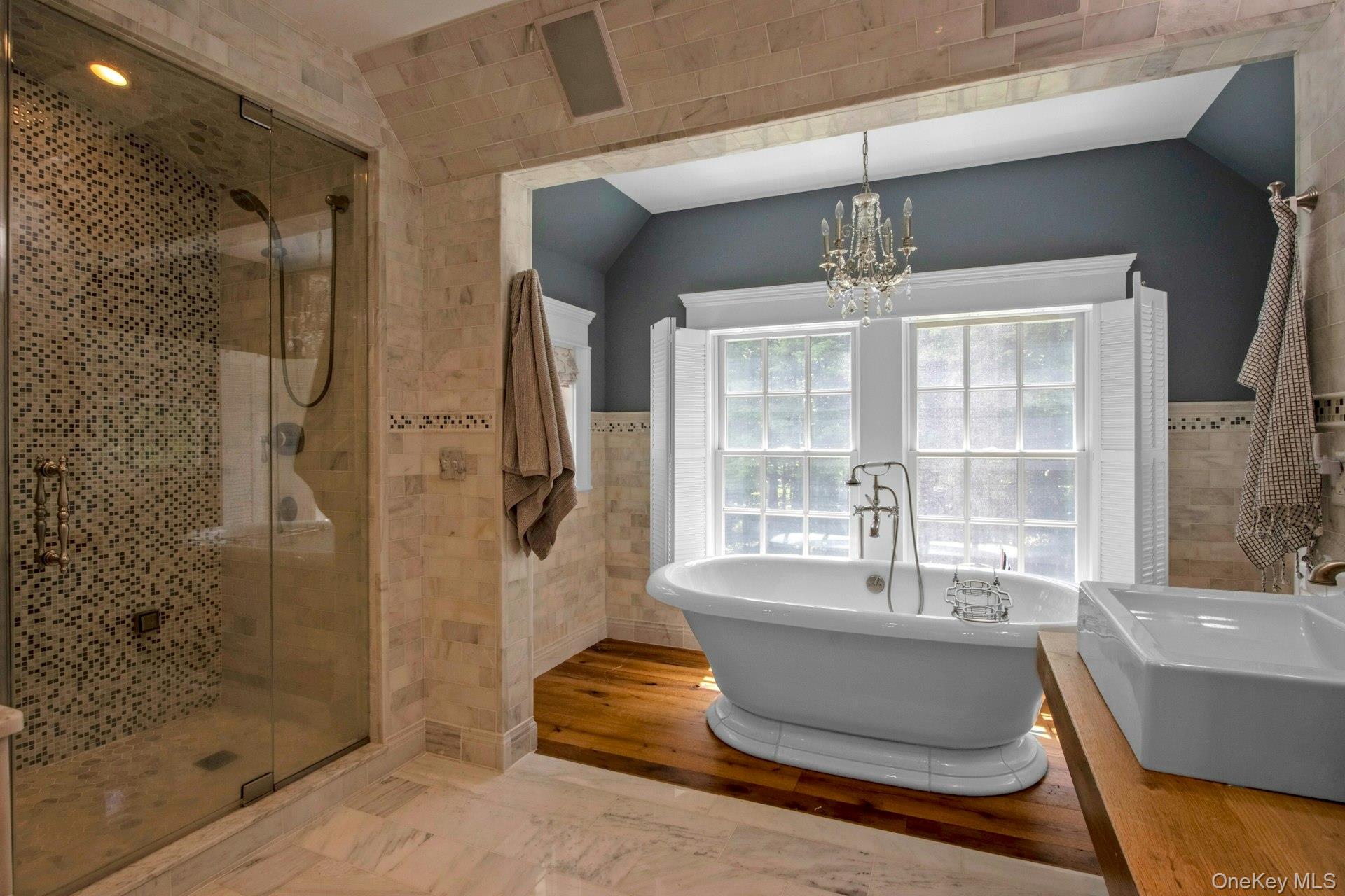 314 Haverstraw Road Suffern, NY 10901 - Photo 30 of 44 Full bathroom featuring tile walls, a soaking tub, a chandelier, a shower stall, and wainscoting
