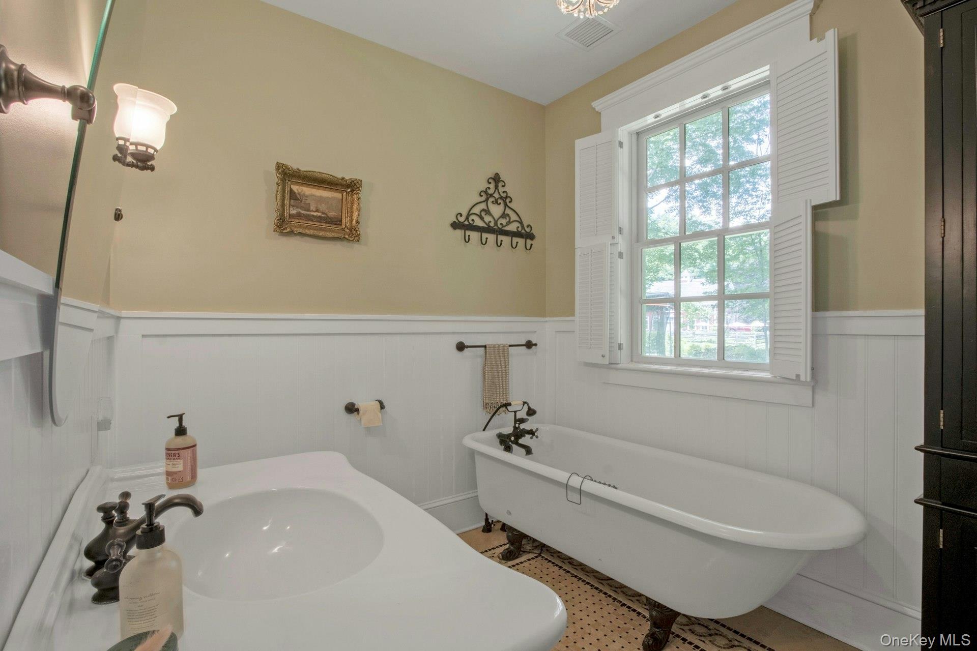 314 Haverstraw Road Suffern, NY 10901 - Photo 32 of 44 Bathroom featuring a wainscoted wall, a freestanding tub, a sink, and a decorative wall