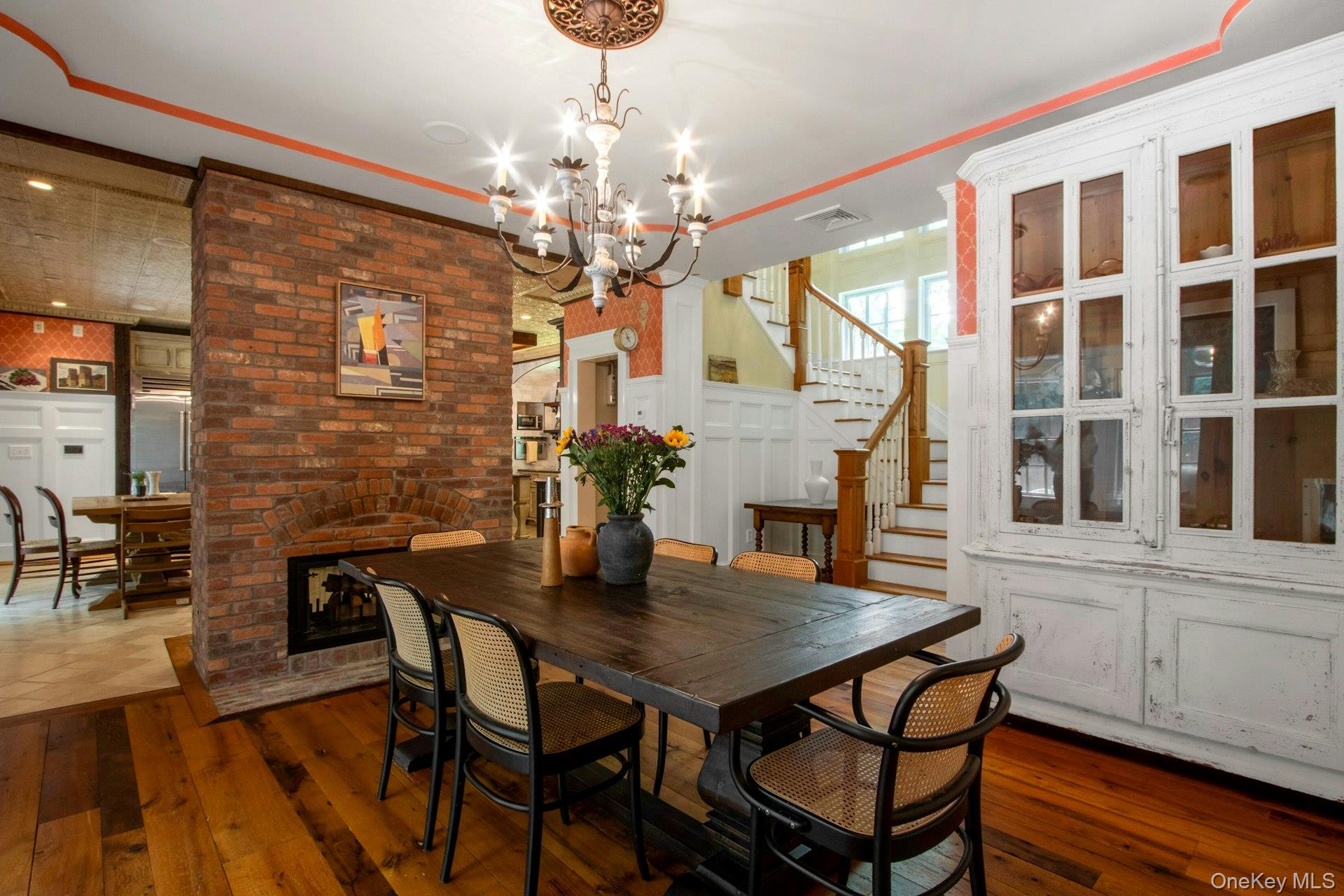 314 Haverstraw Road Suffern, NY 10901 - Photo 8 of 44 Dining room with dark wood-style floors, a chandelier, stairs, and a fireplace